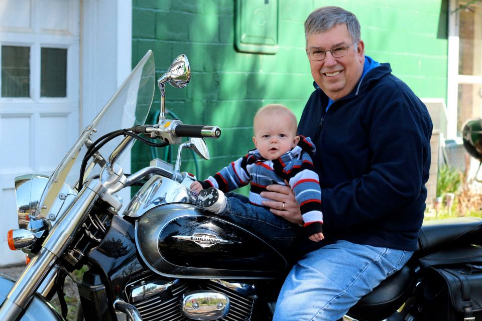 man on a motorcycle with a baby