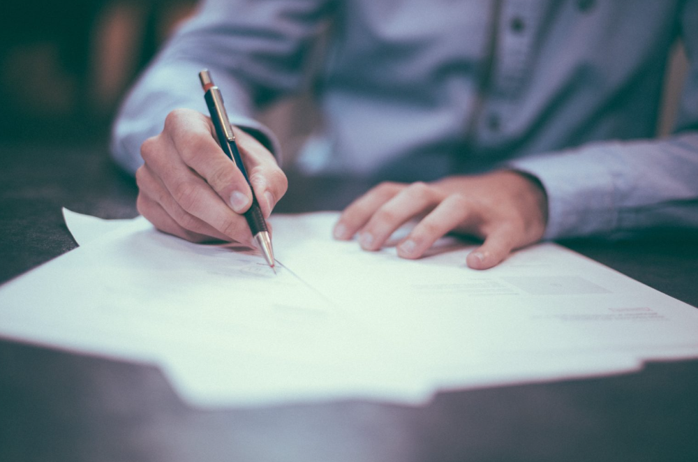 man-writing-at-desk