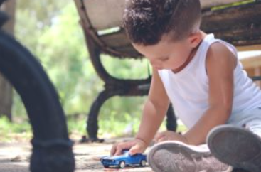 little boy playing with a car