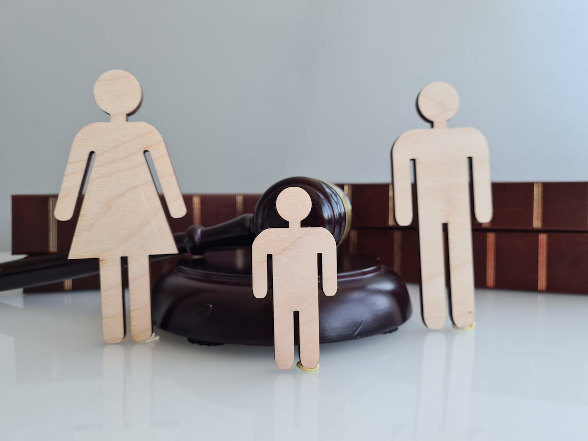 Wood cutouts of a family on a desk with a gavel